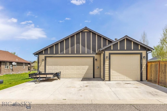 304 Farmall Ln, Manhattan, MT 59741 - view of front of home with board and batten siding, fence, concrete driveway, and a garage
