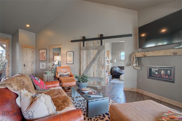11762 Gooch Hill Rd, Gallatin Gateway, MT 59730 - living area featuring a barn door, wood-type flooring, plenty of natural light, baseboards, and high vaulted ceiling