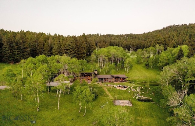 aerial view of property and surrounding area featuring a forest