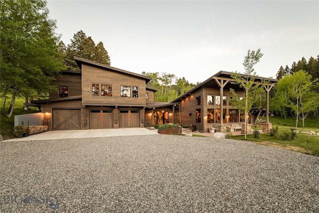 view of front of home featuring a garage and gravel driveway