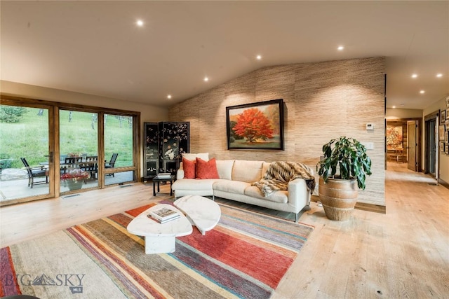 living area featuring lofted ceiling, light wood-style floors, and recessed lighting