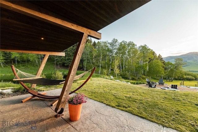view of play area with a lawn, a mountain view, and a patio area
