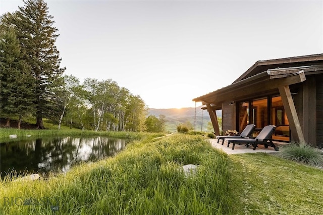 view of yard featuring a patio area and a water and mountain view