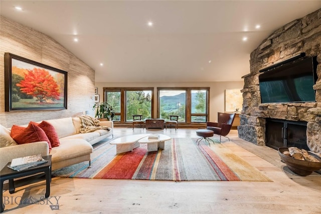 living area featuring a fireplace, high vaulted ceiling, and recessed lighting