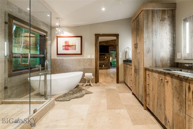 bathroom featuring vanity, tile walls, a soaking tub, recessed lighting, and a shower stall