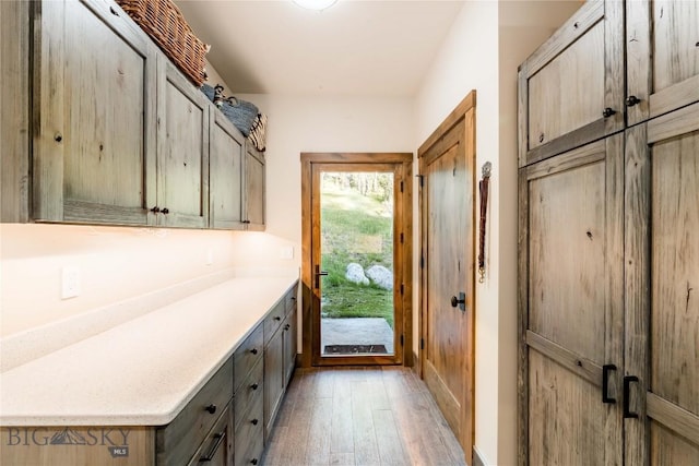 mudroom featuring light wood finished floors and baseboards