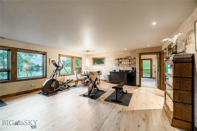 exercise room with light wood-style floors and baseboards