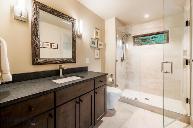 bathroom with toilet, a shower stall, and vanity