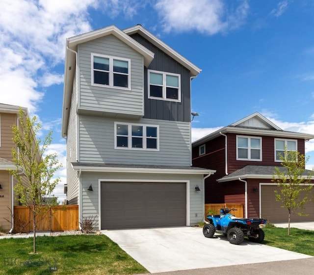 view of front of home featuring board and batten siding, an attached garage, fence, and driveway