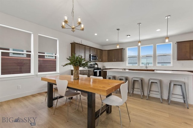 dining area featuring light wood-style flooring, recessed lighting, and a chandelier