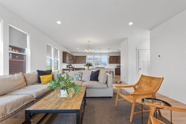living area featuring a chandelier, recessed lighting, and baseboards
