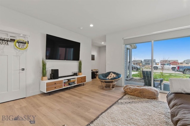 living room with light wood-style floors, recessed lighting, and baseboards