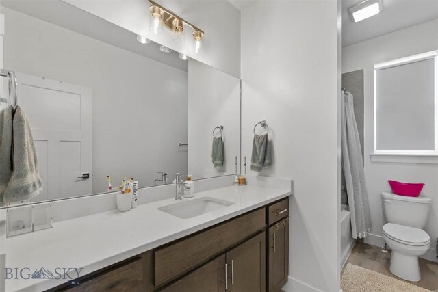 full bath featuring toilet, vanity, wood finished floors, shower / bath combo, and baseboards
