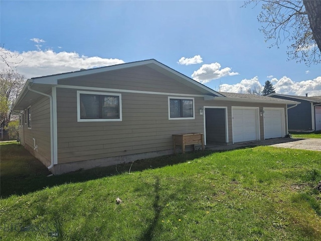 view of property exterior with a garage, a lawn, and driveway