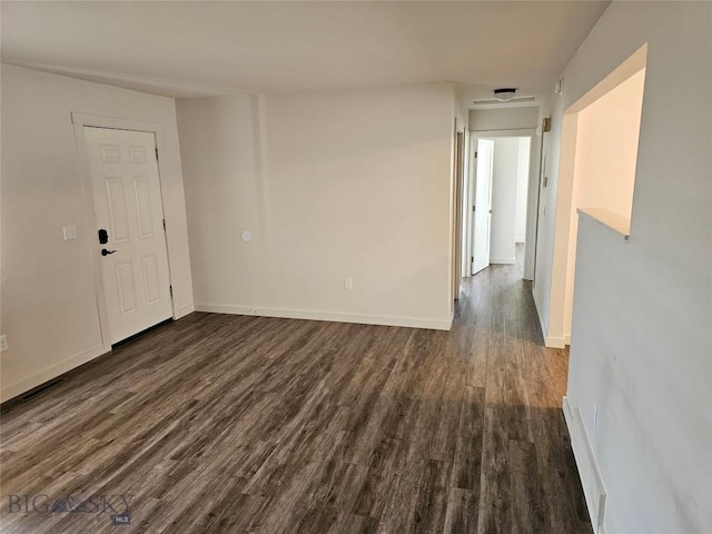 unfurnished room featuring dark wood-style floors and baseboards