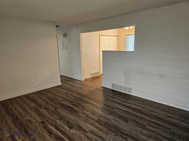 spare room with dark wood finished floors and baseboards