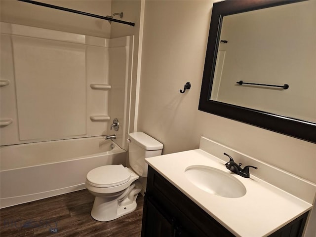 bathroom with toilet, wood finished floors, vanity, and  shower combination