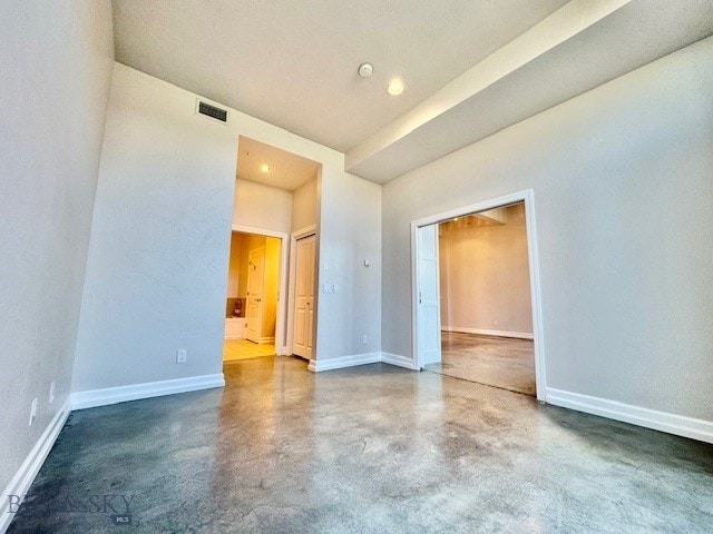 empty room featuring concrete floors and baseboards