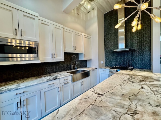 kitchen featuring appliances with stainless steel finishes, a sink, tasteful backsplash, light stone countertops, and marble finish flooring