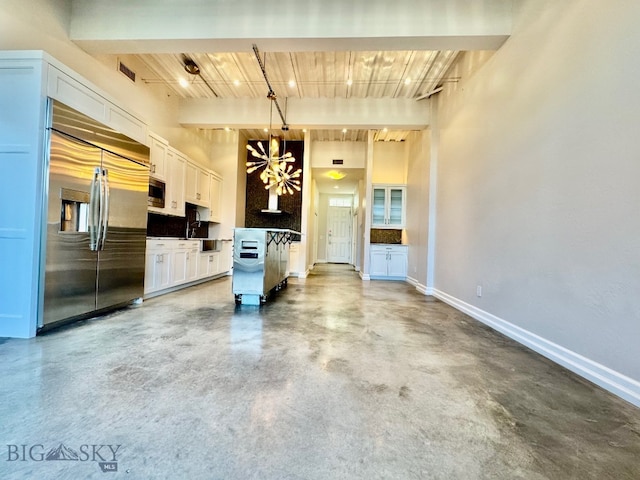kitchen featuring built in appliances, finished concrete floors, white cabinets, beam ceiling, and wooden ceiling