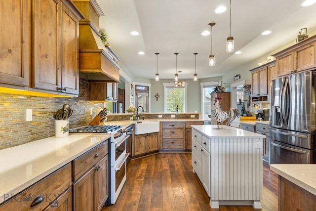 754 Milestone Dr, Belgrade, MT 59714 - kitchen with stainless steel fridge with ice dispenser, range with two ovens, a sink, a peninsula, and brown cabinetry