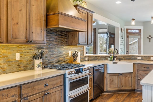 754 Milestone Dr, Belgrade, MT 59714 - kitchen with high end stove, stainless steel dishwasher, custom range hood, brown cabinetry, and light countertops