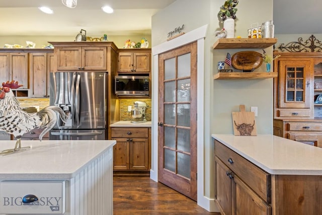 754 Milestone Dr, Belgrade, MT 59714 - kitchen featuring appliances with stainless steel finishes, dark wood-style floors, brown cabinetry, decorative backsplash, and recessed lighting