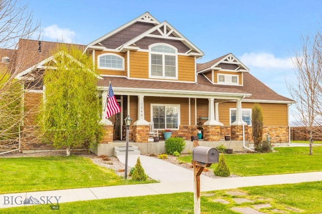754 Milestone Dr, Belgrade, MT 59714 - craftsman house with a front yard, a porch, roof with shingles, and stone siding