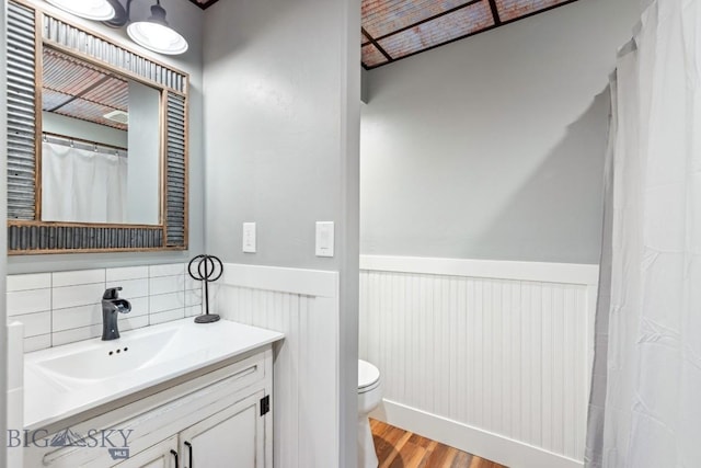 754 Milestone Dr, Belgrade, MT 59714 - bathroom featuring a wainscoted wall, toilet, wood finished floors, and vanity