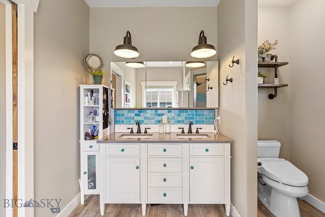 754 Milestone Dr, Belgrade, MT 59714 - full bath featuring backsplash, toilet, wood finished floors, double vanity, and baseboards
