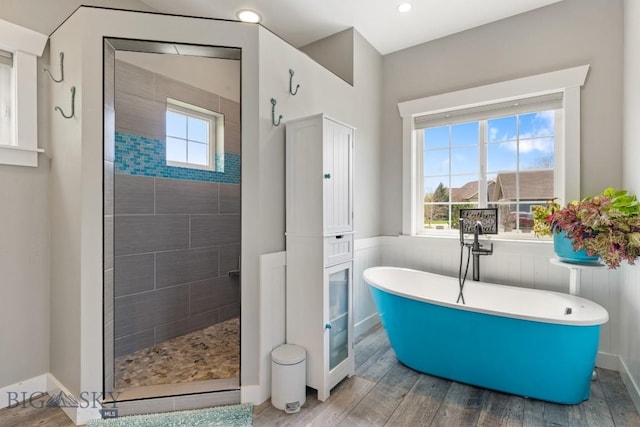 754 Milestone Dr, Belgrade, MT 59714 - bathroom featuring a freestanding tub, healthy amount of natural light, walk in shower, a wainscoted wall, and wood finished floors