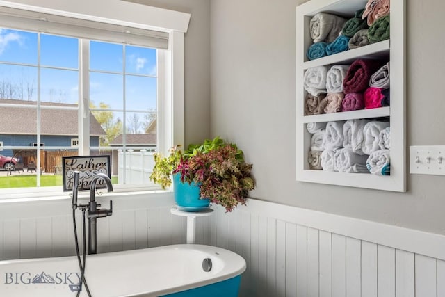 754 Milestone Dr, Belgrade, MT 59714 - full bathroom featuring a freestanding tub, a wainscoted wall, and a sink