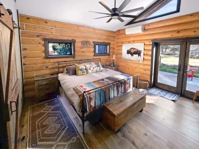 bedroom with a wall mounted AC, vaulted ceiling, log walls, hardwood / wood-style floors, and access to outside