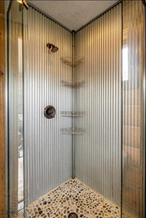 full bath with a shower and a textured ceiling
