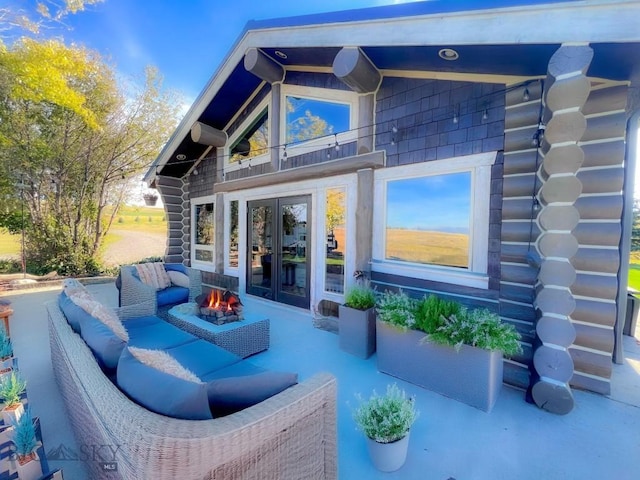 rear view of property featuring french doors, log exterior, an outdoor living space with a fire pit, and a balcony