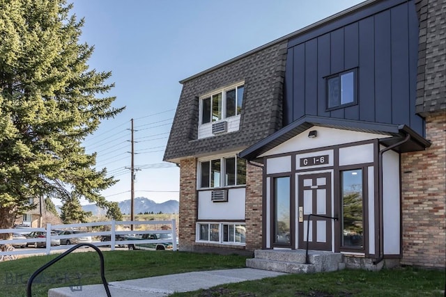 view of front of property featuring brick siding, a mountain view, a shingled roof, and entry steps