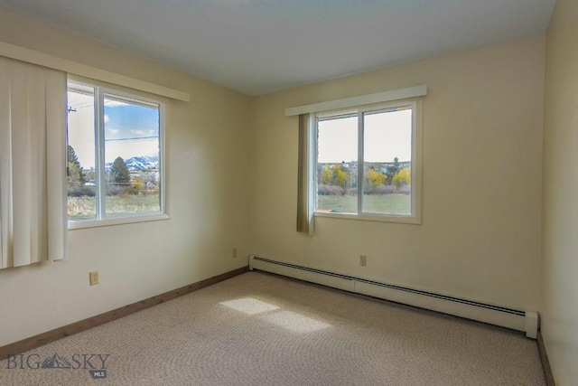 unfurnished room with baseboard heating, carpet floors, and baseboards