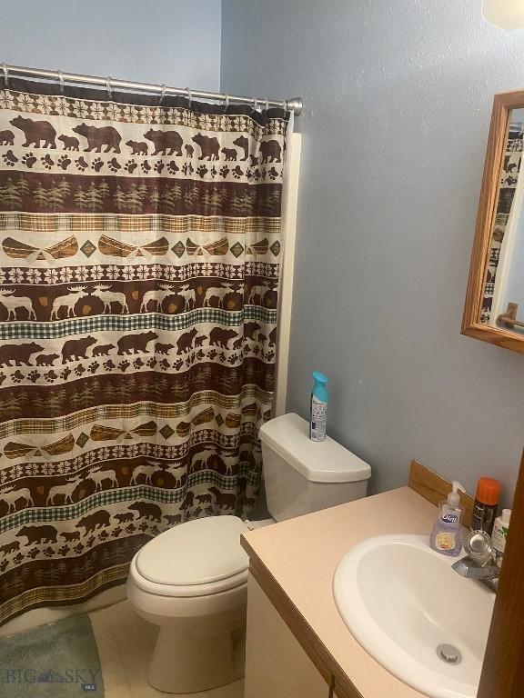 303 Treasure, Bozeman, MT 59718 - full bath featuring vanity, toilet, curtained shower, and tile patterned floors