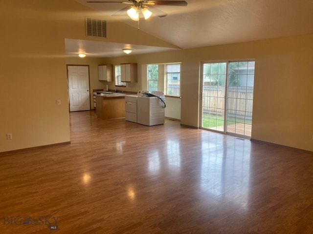 303 Treasure, Bozeman, MT 59718 - unfurnished living room with ceiling fan, dark wood finished floors, lofted ceiling, and washer and dryer