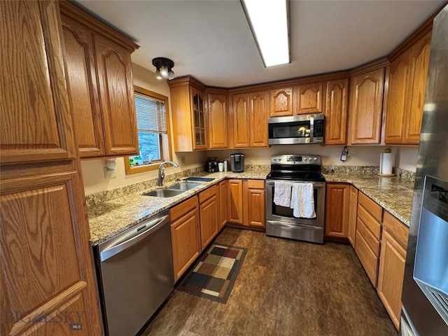 105 Country Club Ln, Butte, MT 59701 - kitchen featuring stainless steel appliances, a sink, brown cabinets, and light stone counters