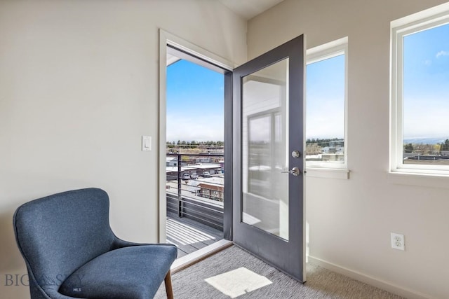 doorway to outside featuring carpet and baseboards