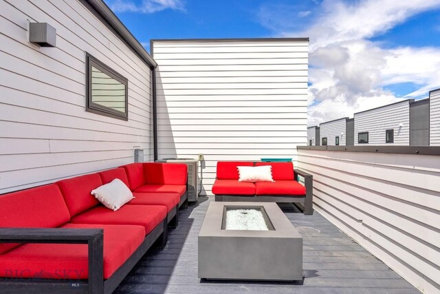 deck featuring an outdoor living space with a fire pit