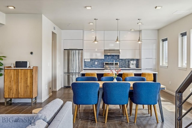 dining area with dark wood-type flooring and baseboards