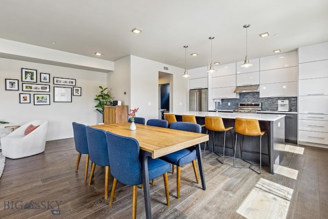 dining area with wood finished floors and recessed lighting