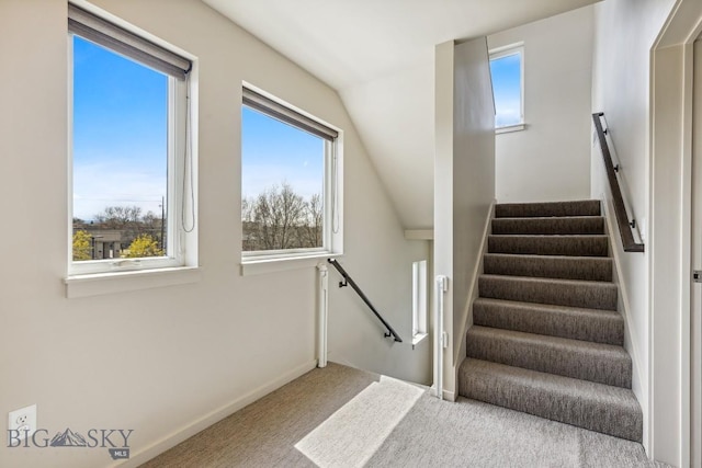 staircase with carpet, lofted ceiling, and baseboards