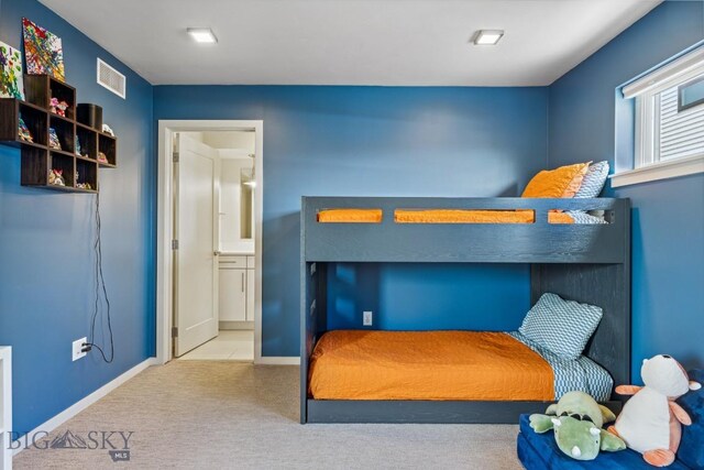 bedroom with carpet, baseboards, and ensuite bath
