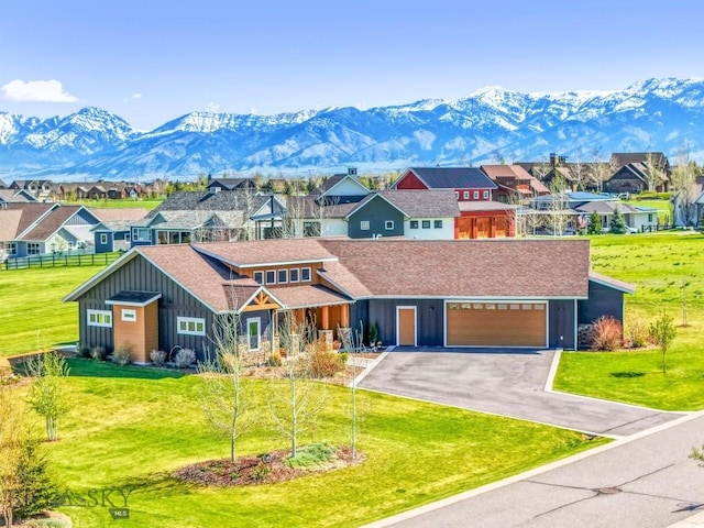 view of front facade with board and batten siding, a mountain view, driveway, and a residential view