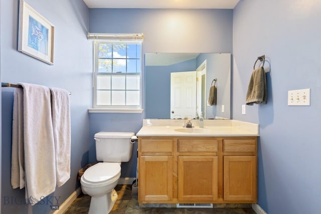 bathroom with baseboards, toilet, and vanity