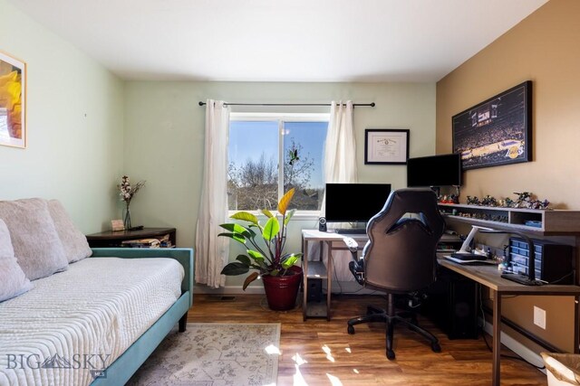 home office with wood finished floors and baseboard heating