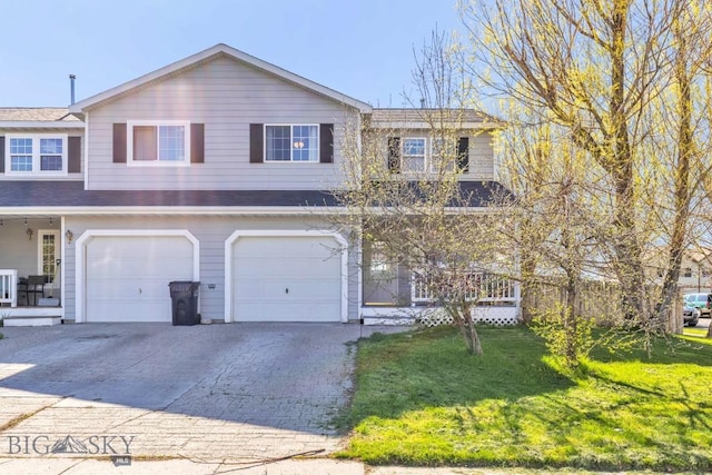 view of front of home featuring driveway, a front yard, and an attached garage